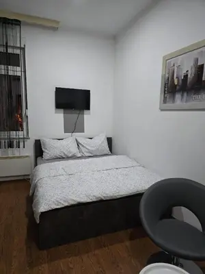 a bedroom with a bed with a tv on the wall at Apartman Wegele in Teslić