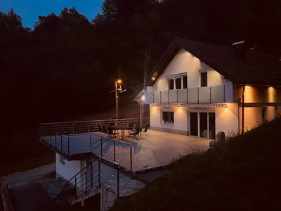 a house with a deck in front of it at night at House in Kreševo - Mountain view - in Kreševo
