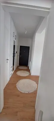 an empty hallway with white walls and wood floors at Delta in Lukavac