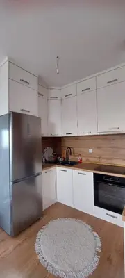 a kitchen with white cabinets and a stainless steel refrigerator at Delta in Lukavac