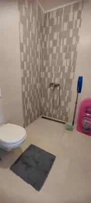 a bathroom with a toilet and a tile wall at Delta in Lukavac