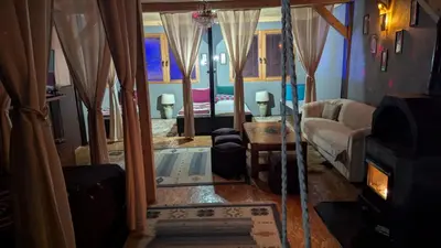 a living room with a couch and a room with a tub at Neno Pyramid Wellness Retreat in Visoko
