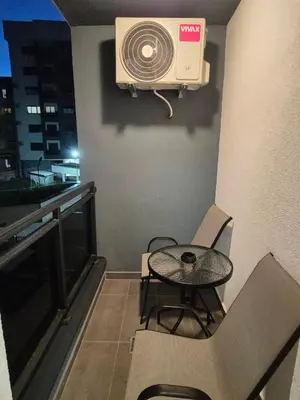 a balcony with a table and a fan on the wall at Apartman Silencio 2 in Banja Luka