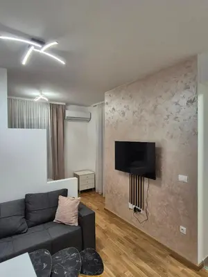 a living room with a couch and a tv on a wall at Apartman Silencio 2 in Banja Luka