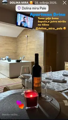 a bottle of wine and two glasses on a table at Drina in Pale