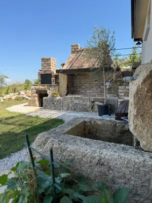 a stone fountain in the yard of a house at Casa Elena in Banja Luka