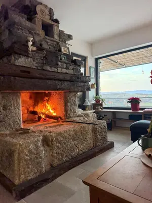 a stone fireplace in a living room with a view at Casa Elena in Banja Luka