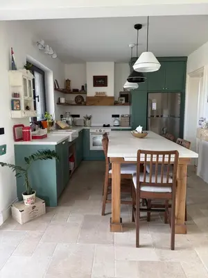 a kitchen with green cabinets and a table and chairs at Casa Elena in Banja Luka
