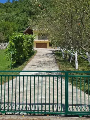 a gate in front of a driveway with a building at Vikendica raj u lohovu in Bihać