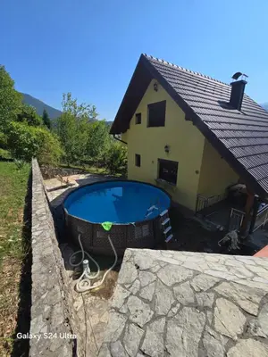 a house with a swimming pool in front of a house at Vikendica raj u lohovu in Bihać