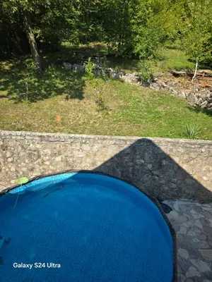 a blue pool of water in a yard at Vikendica raj u lohovu in Bihać