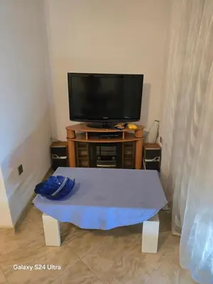 a living room with a tv and a table at Vikendica raj u lohovu in Bihać