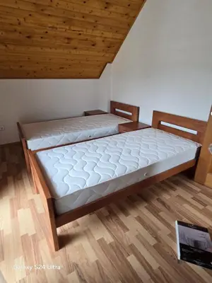 two beds in a room with a wooden ceiling at Vikendica raj u lohovu in Bihać