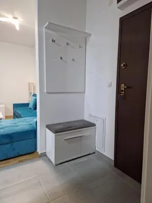 a room with a bed and a table and a door at Stan na Dan 39- PLAVI in Banja Luka
