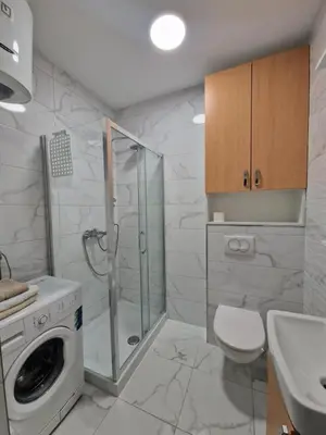 a bathroom with a shower and a washing machine at Stan na Dan 39- PLAVI in Banja Luka