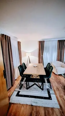 a dining room with a table and chairs and a couch at Holiday House M&M Kupres in Kupres