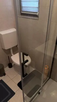 a bathroom with a toilet and a glass shower door at Holiday House M&M Kupres in Kupres