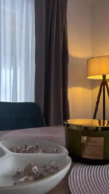 a plate of food on a table next to a lamp at Holiday House M&M Kupres in Kupres