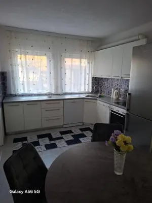 a kitchen with a table and a refrigerator at Avenue in Bosanska Krupa