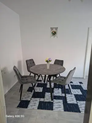a dining room table with chairs and a vase of flowers at Avenue in Bosanska Krupa