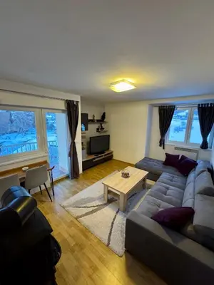 a living room with a couch and a table at Apartman Zimski Kutak in Kupres