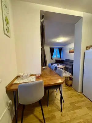 a dining room with a table and a couch at Apartman Zimski Kutak in Kupres