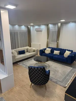 a living room with two blue couches and a couch at Stan na dan Jelah in Jelah