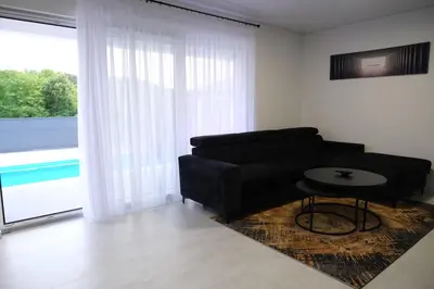 a living room with a black couch and a table at Luxury Villa JAKOV in Banja Luka
