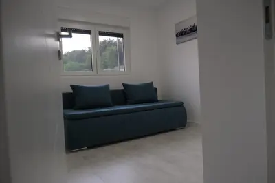 a blue couch in a room with a window at Luxury Villa JAKOV in Banja Luka