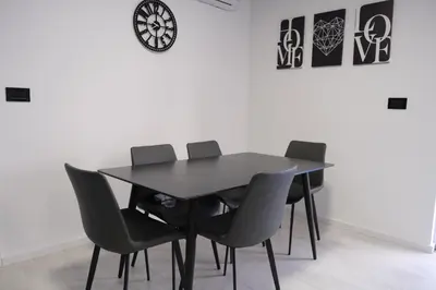 a black table and chairs in a room with a clock at Luxury Villa JAKOV in Banja Luka