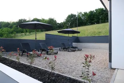 a group of chairs and umbrellas in a courtyard at Luxury Villa JAKOV in Banja Luka
