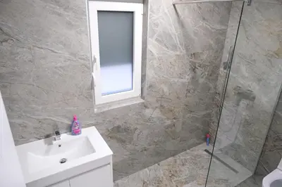 a bathroom with a shower and a sink and a mirror at Luxury Villa JAKOV in Banja Luka