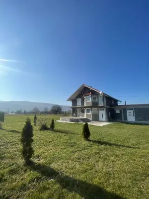 a house in the middle of a grassy field at Porodični mir in Bugojno