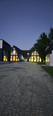 a large building with a building with lights on at Golden Spa A-Frame 2 in Bihać