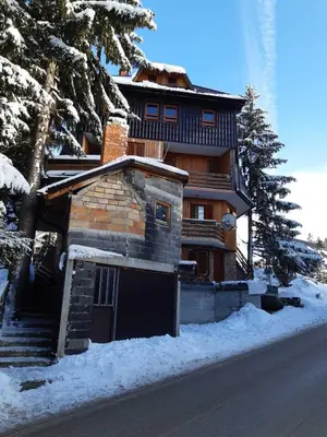 a house with a garage in the snow at Apartmani Adin Babanovac in Travnik