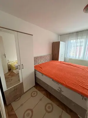 a small bedroom with a bed with a mirror at Apartman Andja in Laktaši