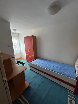 a small room with a bed and a red cabinet at Apartman Andja in Laktaši