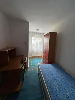 an empty room with a bed and a desk at Apartman Andja in Laktaši