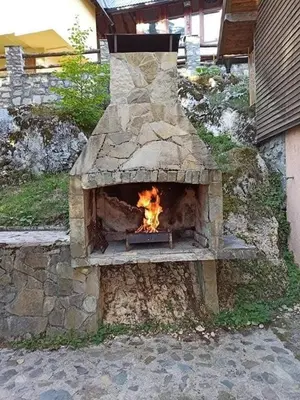 a stone oven with a fire inside of it at Vikendica SANA Vlašić in Šišava