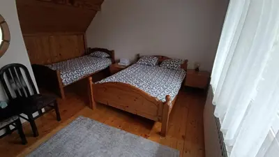 a room with two beds and a chair in it at Vikendica SANA Vlašić in Šišava