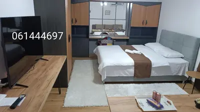a bedroom with a bed and a tv and a table at Galija in Velika Kladuša