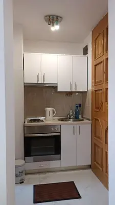 a kitchen with white cabinets and a stove top oven at Galija in Velika Kladuša