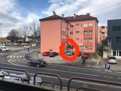 a view of a street with cars parked in front of a building at Galija in Velika Kladuša