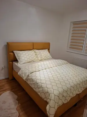 a bedroom with a bed with a white comforter and a window at Apartman Idea 2 in Tuzla