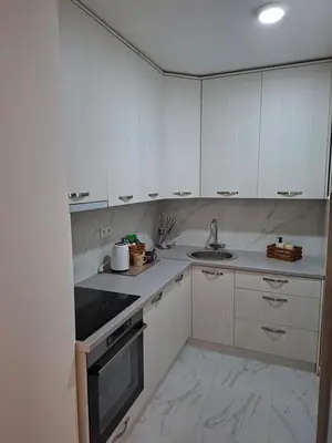 a kitchen with white cabinets and a sink at Apartman Idea 2 in Tuzla
