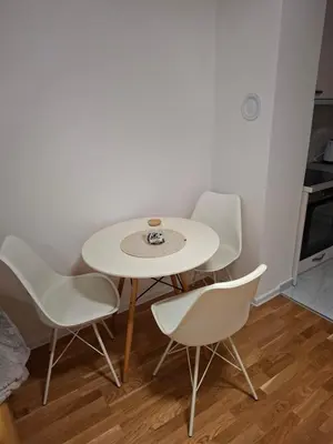 a white table and four chairs in a room at Apartman Idea 2 in Tuzla