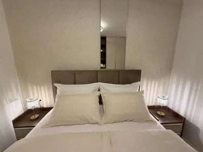 a large bed with white sheets and pillows at Stelmar Apartment in Banja Luka