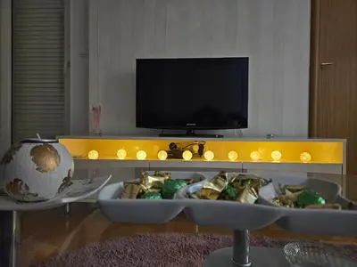 a living room with a tv and a table with food at Apartman Magic in Banja Luka