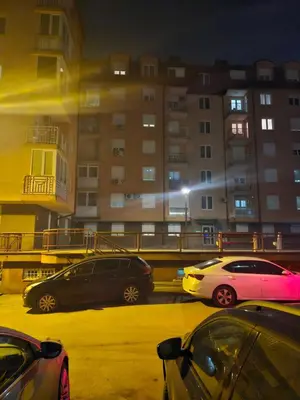 three cars parked in a parking lot at night at Apartman Magic in Banja Luka