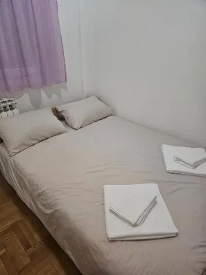 a bed with two white plates and utensils on it at Apartman Magic in Banja Luka